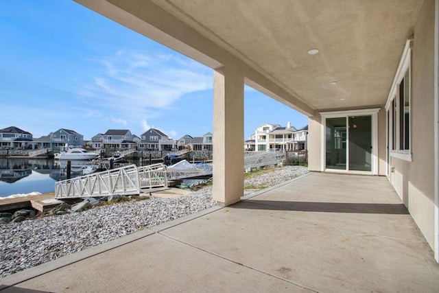 view of patio / terrace featuring a water view and a dock