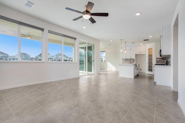 unfurnished living room with ceiling fan and light tile patterned floors