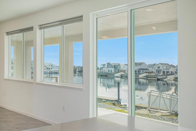 entryway featuring tile patterned flooring, a healthy amount of sunlight, and a water view