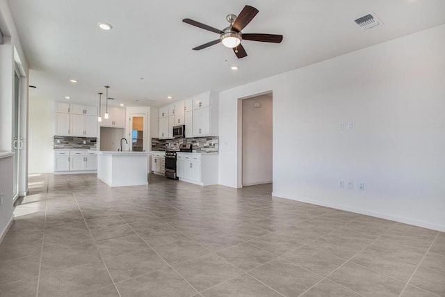 unfurnished living room with ceiling fan, light tile patterned floors, and sink