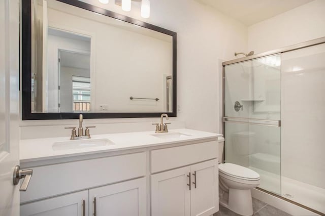 bathroom with tile patterned flooring, vanity, toilet, and an enclosed shower