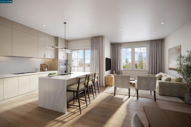 kitchen featuring pendant lighting, white appliances, a kitchen island with sink, light hardwood / wood-style flooring, and a breakfast bar