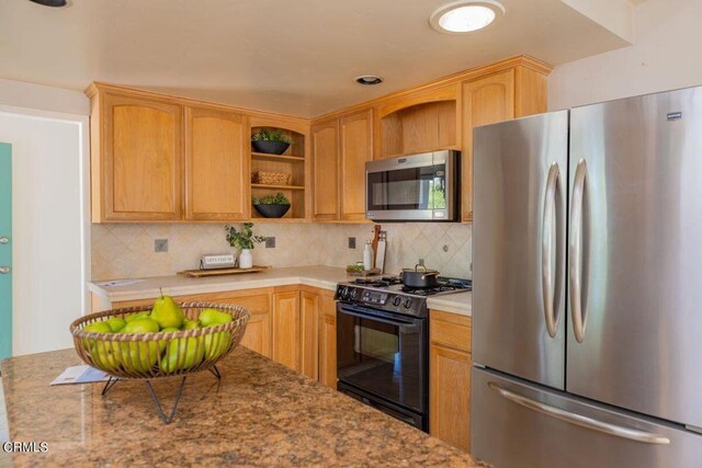 kitchen with stainless steel appliances, light brown cabinets, and tasteful backsplash