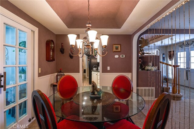 dining space with a tray ceiling and an inviting chandelier