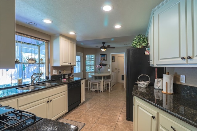 kitchen featuring dark stone counters, sink, white cabinets, black appliances, and ceiling fan