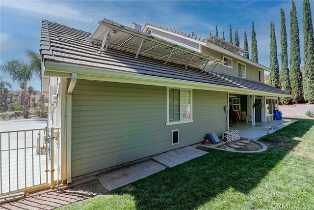 rear view of house with a lawn and a patio