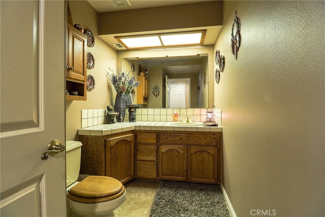 bathroom with tile patterned flooring, vanity, and toilet