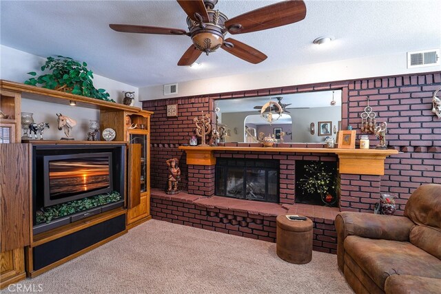 carpeted living room with a brick fireplace, a textured ceiling, and ceiling fan