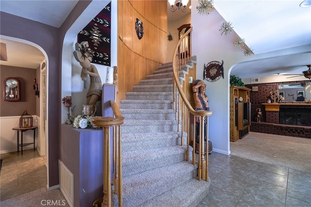 stairway featuring carpet and a fireplace