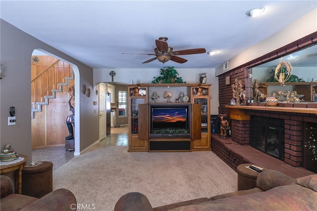 carpeted living room featuring a textured ceiling, a fireplace, and ceiling fan