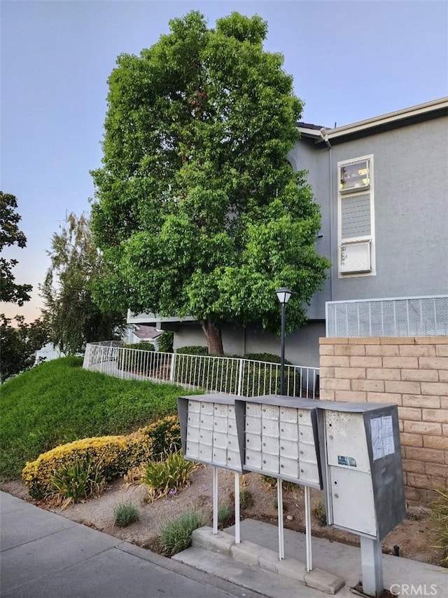 view of property's community with mail area and fence