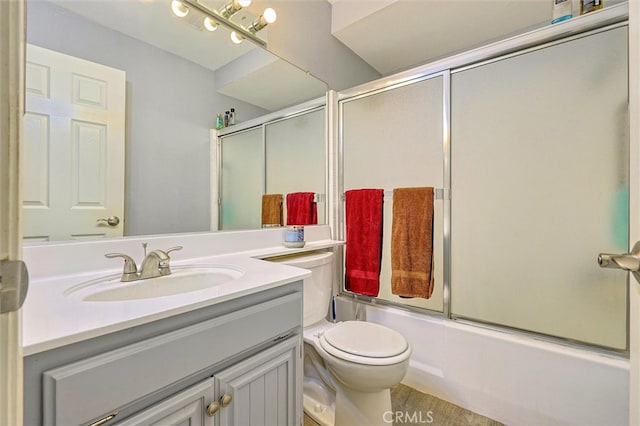 full bathroom featuring enclosed tub / shower combo, vanity, and toilet