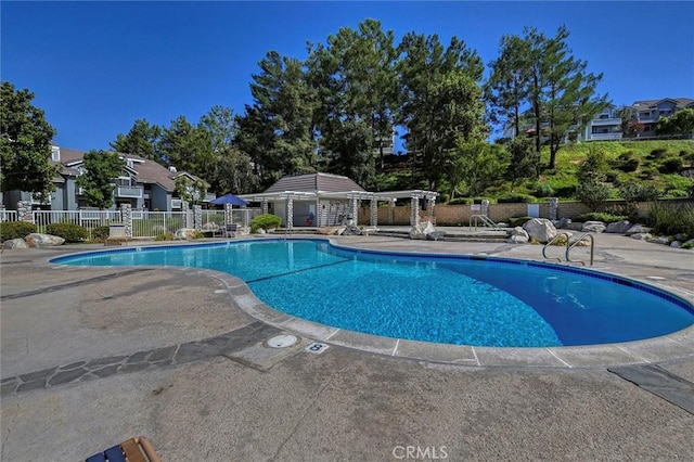 pool with a patio and fence