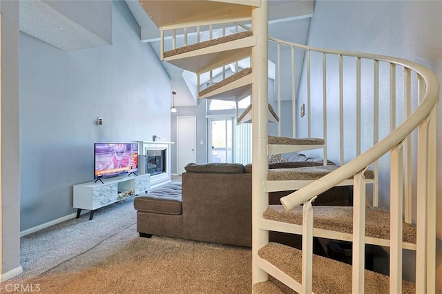 stairway with baseboards, carpet, a towering ceiling, and a fireplace