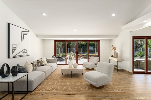 living room featuring wood-type flooring and lofted ceiling