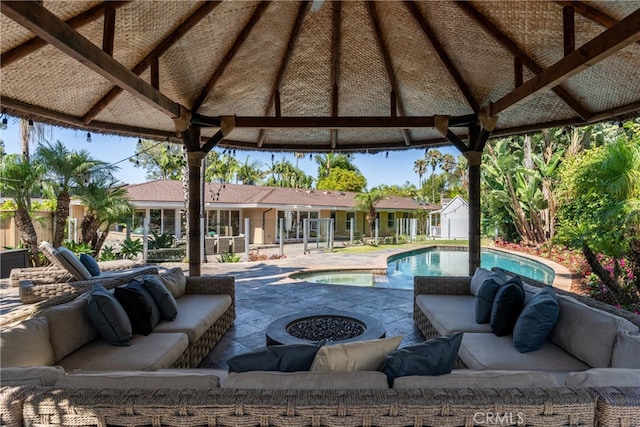 view of patio with a storage unit, a gazebo, and an outdoor living space with a fire pit