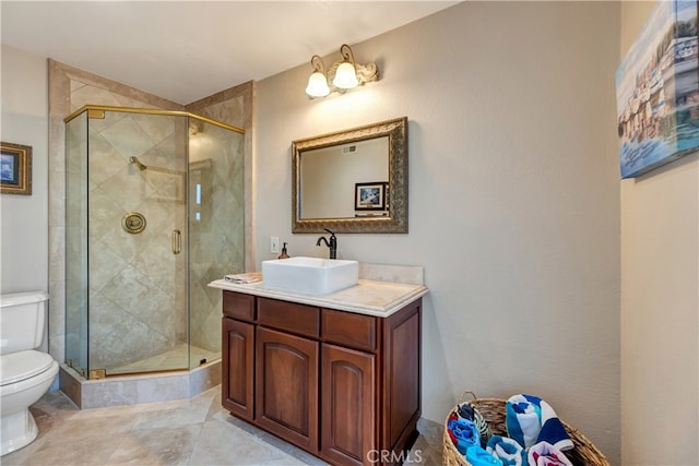 bathroom featuring tile patterned flooring, vanity, toilet, and a shower with door