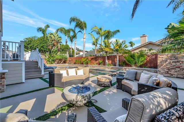 view of patio with an outdoor living space with a fire pit