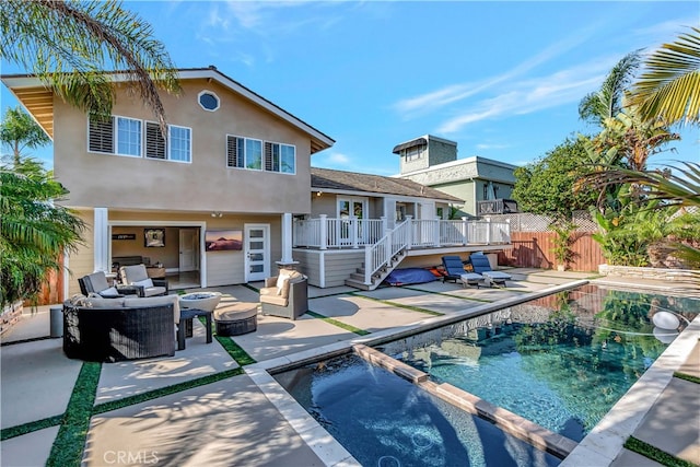 rear view of property with an in ground hot tub and a patio area