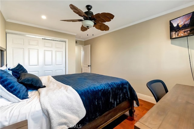 bedroom featuring hardwood / wood-style flooring, ornamental molding, ceiling fan, and a closet