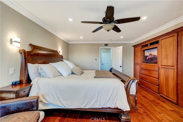 bedroom with ceiling fan, dark hardwood / wood-style floors, and crown molding