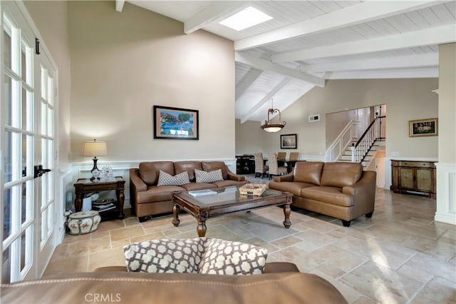 living room featuring french doors, beamed ceiling, and high vaulted ceiling