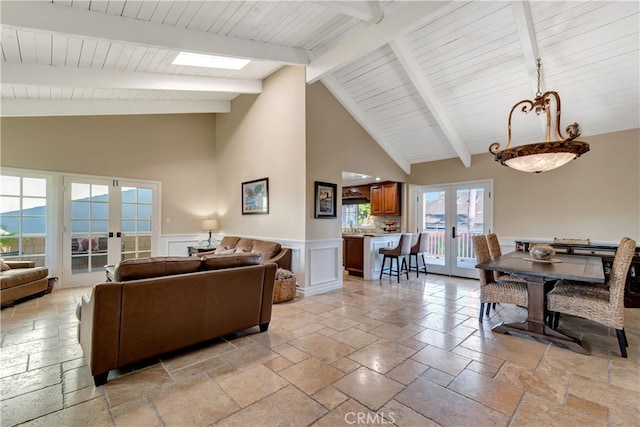 living room featuring high vaulted ceiling, beamed ceiling, and french doors