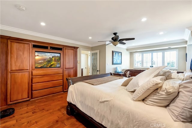 bedroom featuring ceiling fan, hardwood / wood-style flooring, and crown molding