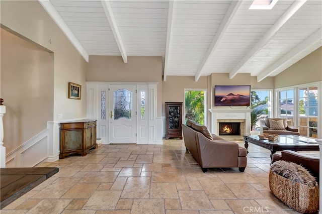 living room with lofted ceiling with beams and a healthy amount of sunlight