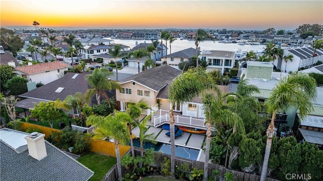 aerial view at dusk featuring a water view