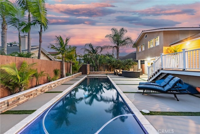 pool at dusk with a patio