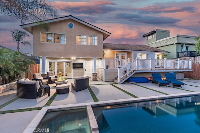 rear view of house with a patio, a pool side deck, and outdoor lounge area