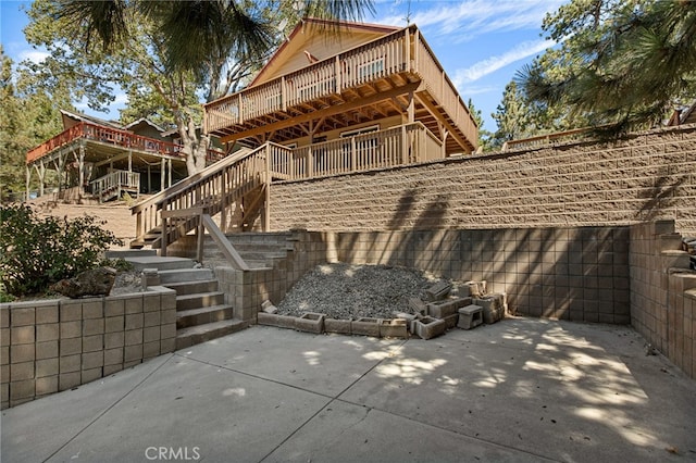 back of property featuring a wooden deck and a patio area