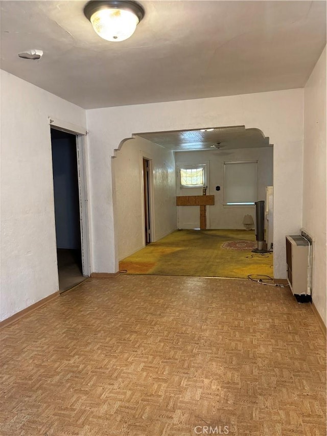 spare room featuring heating unit and parquet floors