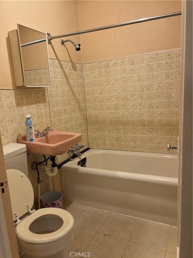 full bathroom with shower / washtub combination, sink, tile walls, tile patterned flooring, and toilet