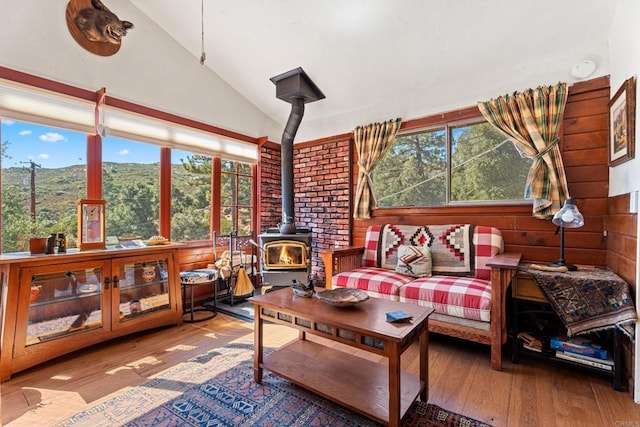 sunroom / solarium with a mountain view, a wood stove, and lofted ceiling