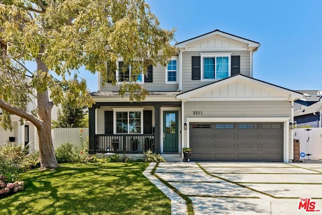 view of front of home with a front yard, a garage, and covered porch