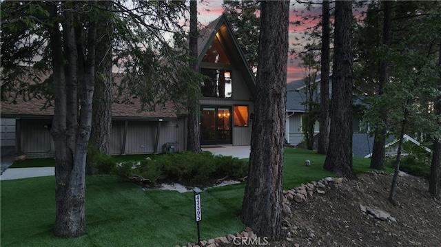 view of front of home featuring roof with shingles and a front yard