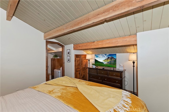 bedroom with lofted ceiling with beams and washing machine and dryer