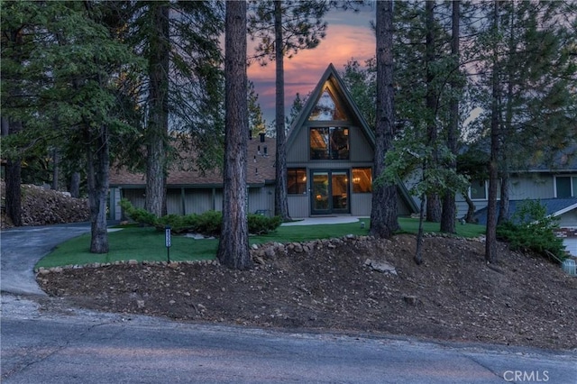 a-frame style home with a front lawn