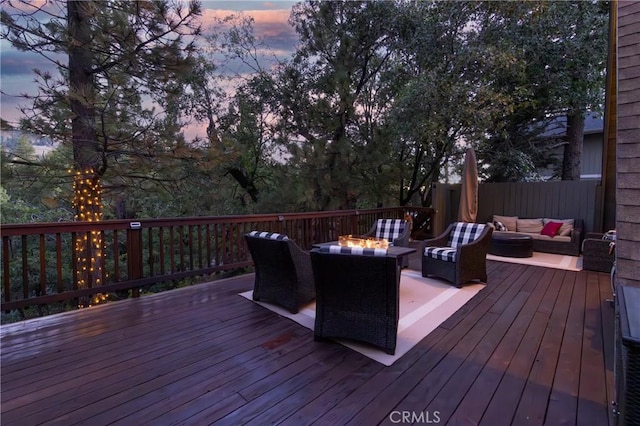 deck at dusk featuring an outdoor living space with a fire pit