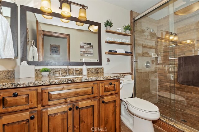 bathroom with vanity, toilet, and a shower with door