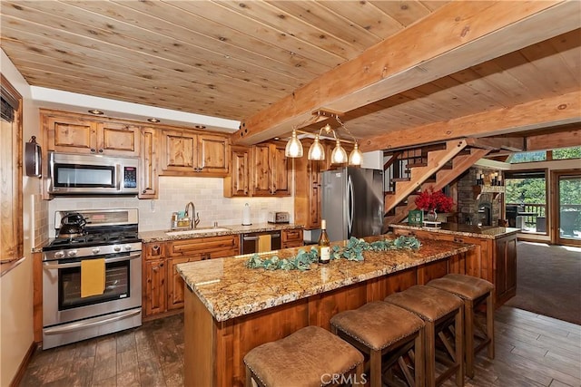 kitchen featuring brown cabinets, dark wood finished floors, stainless steel appliances, decorative backsplash, and a sink