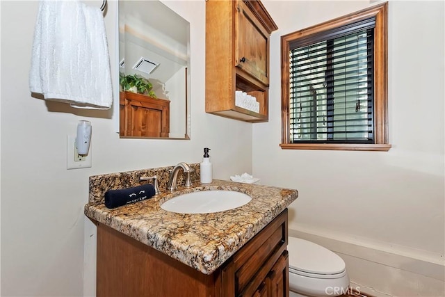 bathroom featuring visible vents, toilet, and vanity