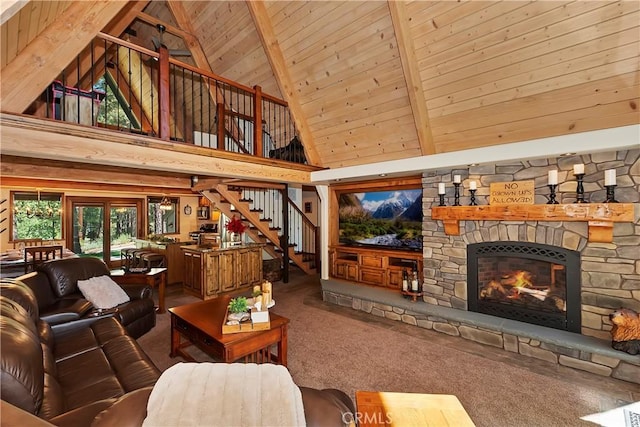 living room with lofted ceiling with beams, wooden ceiling, a fireplace, carpet flooring, and stairway