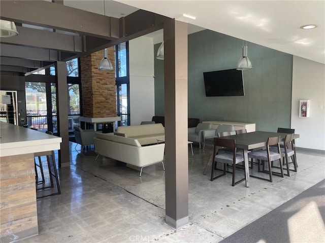 dining space with concrete flooring and a high ceiling