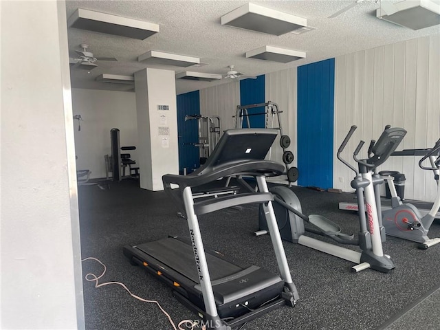 workout area featuring ceiling fan and a textured ceiling