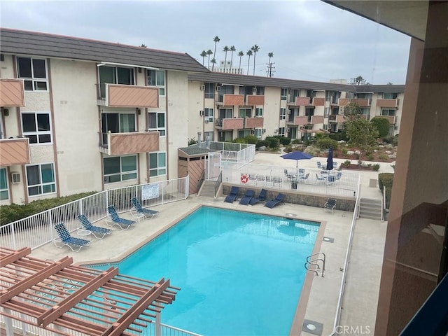 community pool featuring a patio area and fence