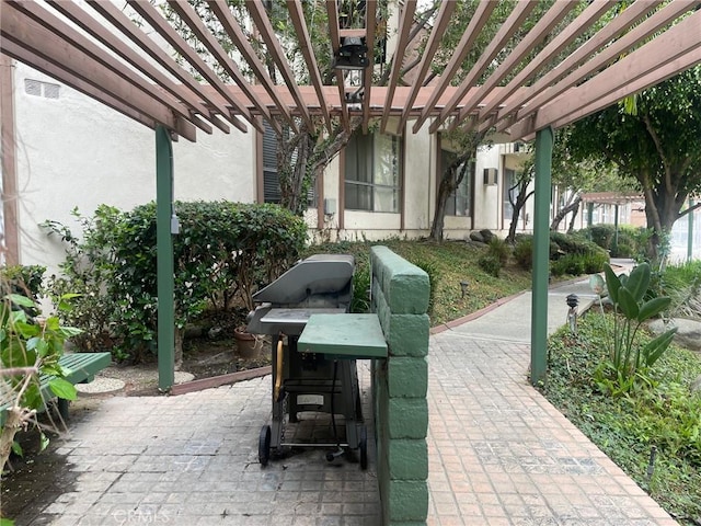 view of patio featuring grilling area and a pergola