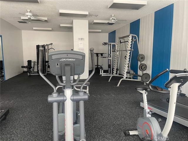 gym featuring ceiling fan and a textured ceiling